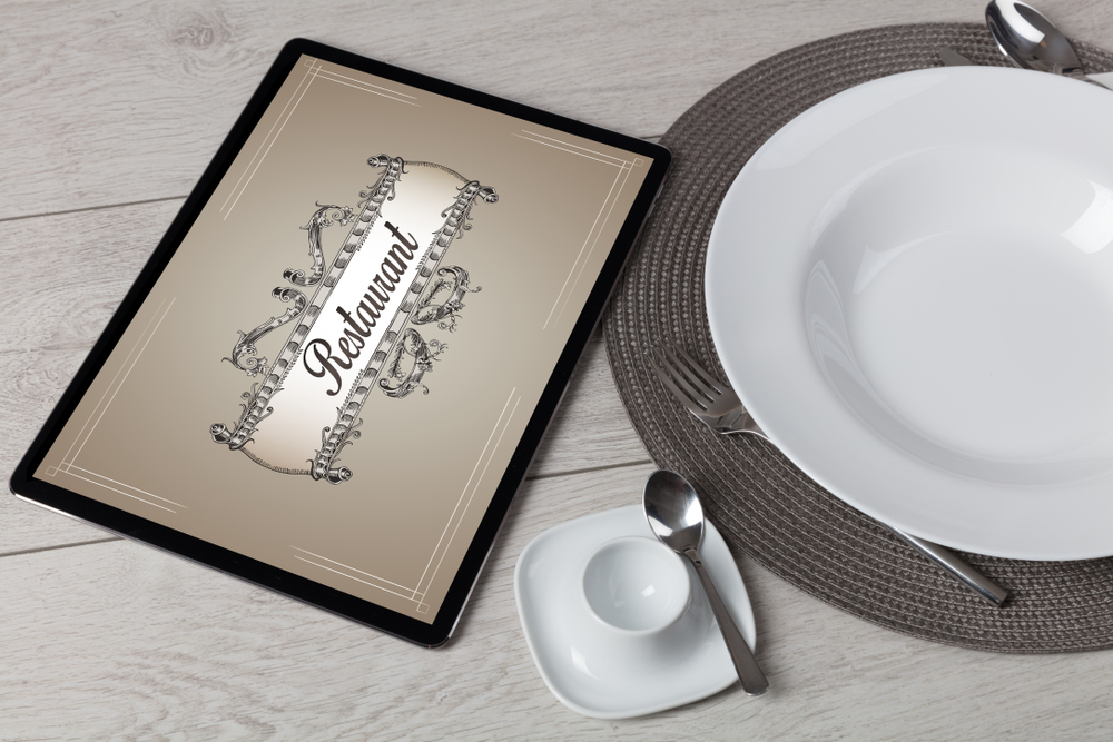 Tablet with stylish restaurant logo and laid table-1